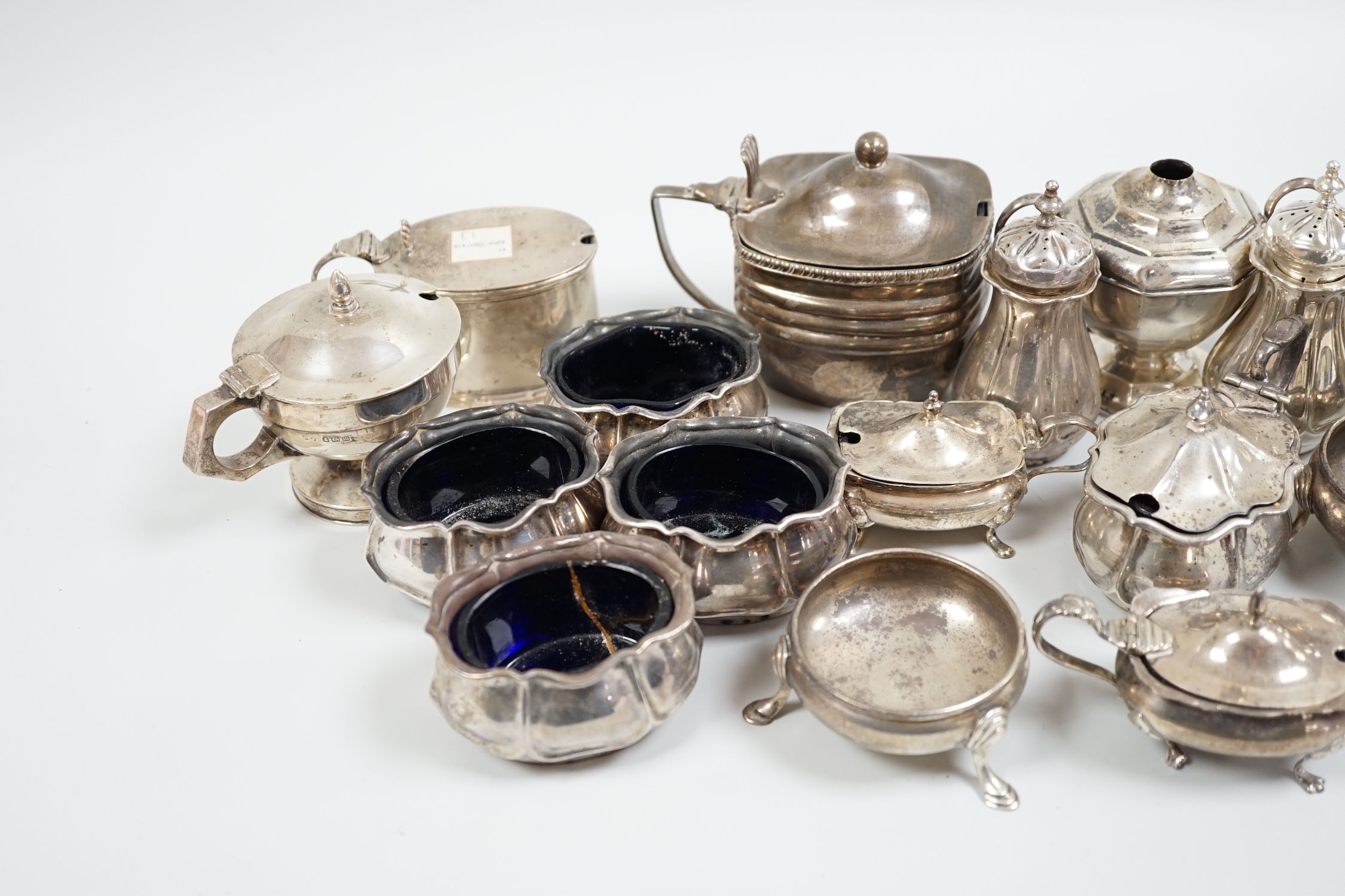 An Edwardian seven piece silver condiment set, Atkin Bros. Sheffield, 1903/4 and eleven other silver condiments including a pair of pepperettes.